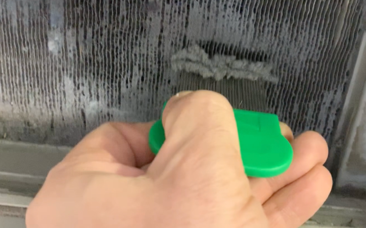 Nettoyage de la grille du condenseur avec un peigne à poux